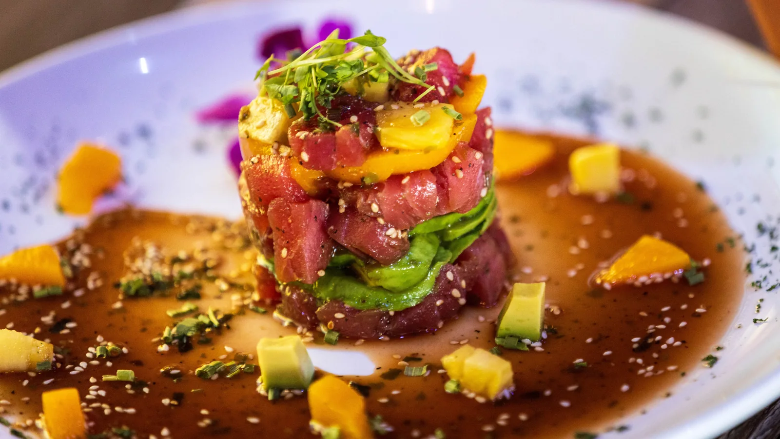 An ahi tuna poke tower with mango and avocado