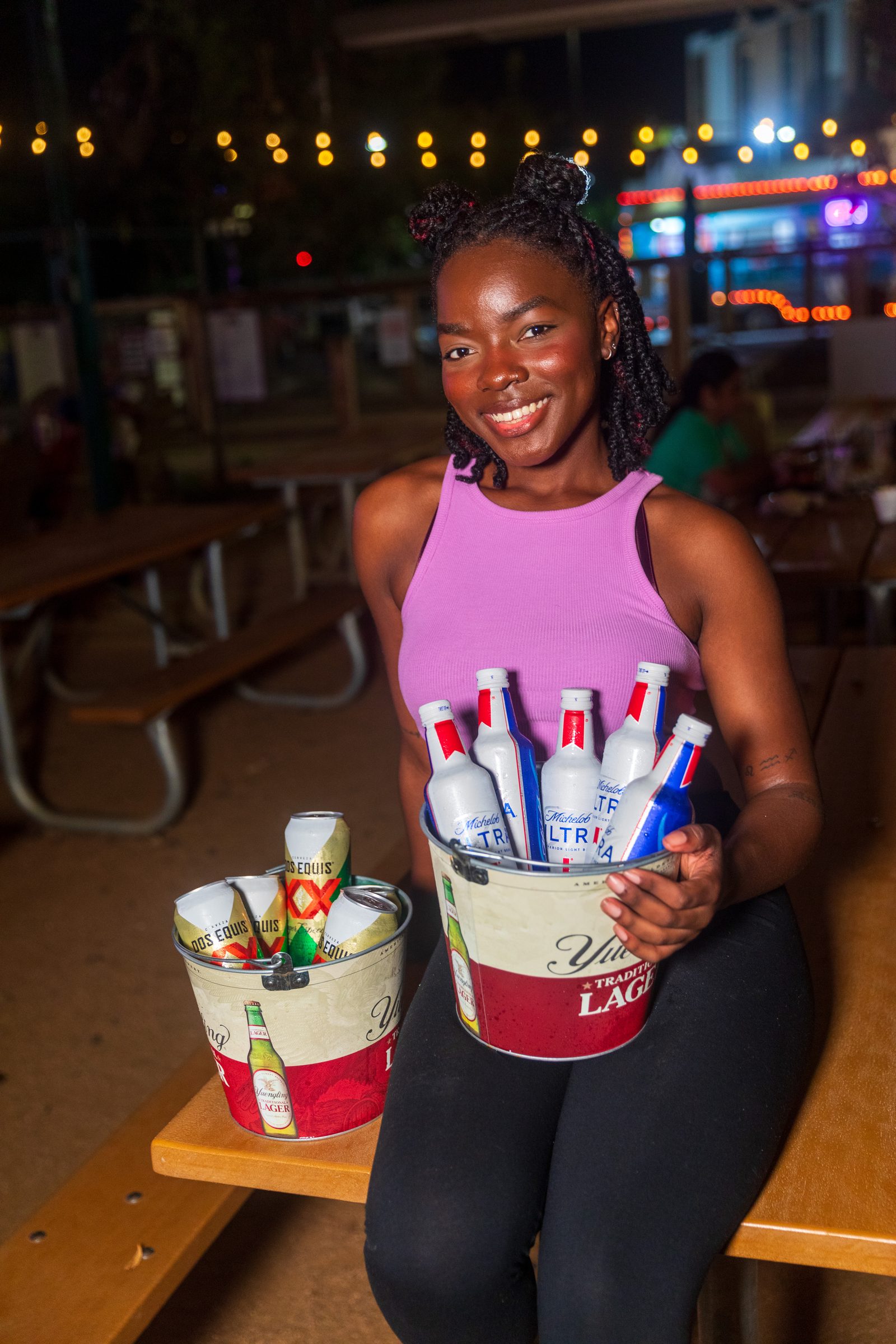 Server with drink buckets at an outdoor San Antonio event