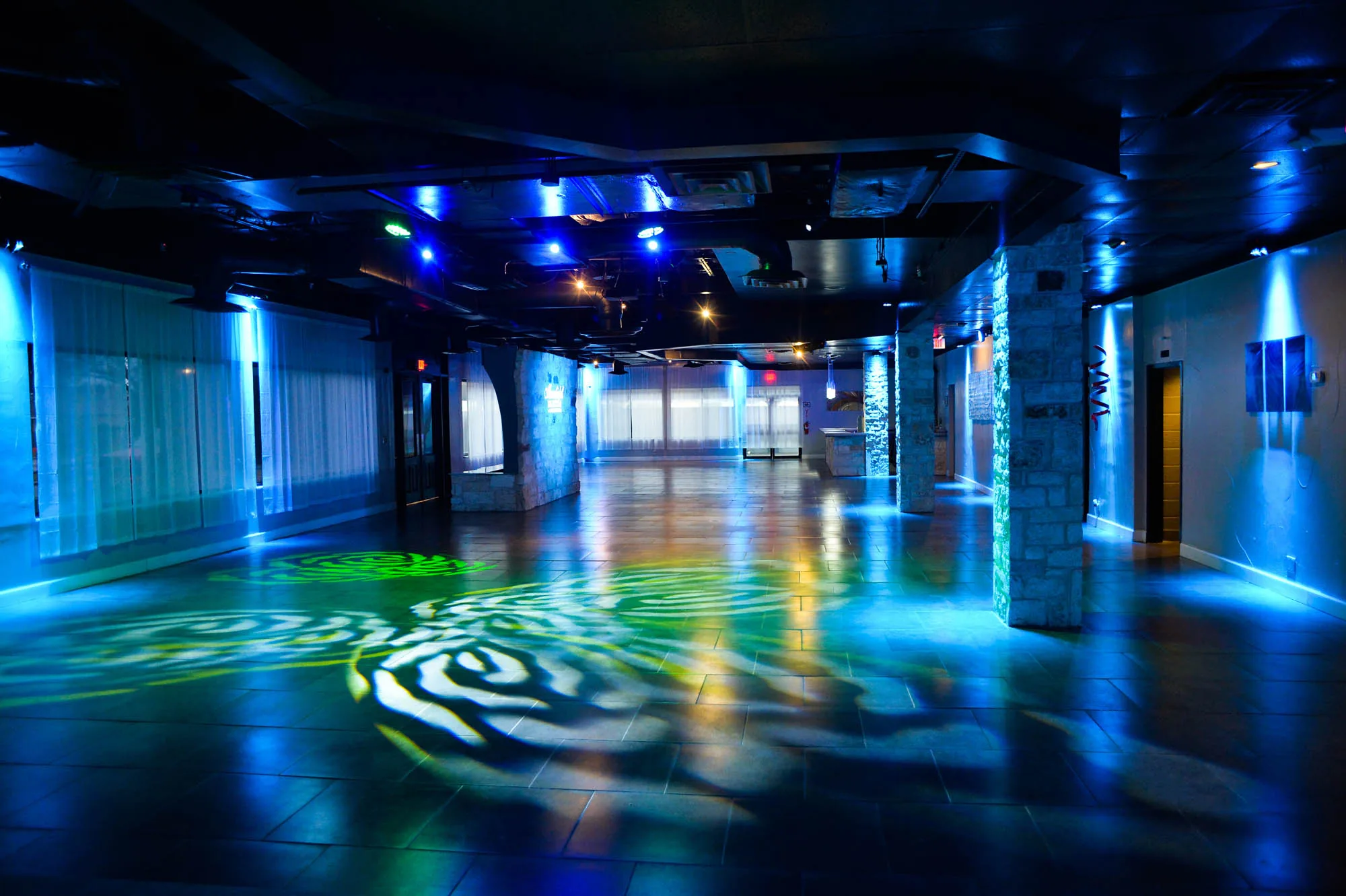The Moonlight Ballroom lit in blue and green with a patterned gobo projection across the open dance floor